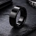 polished-black-tungsten-carbide-ring-flat-on-desk.webp
